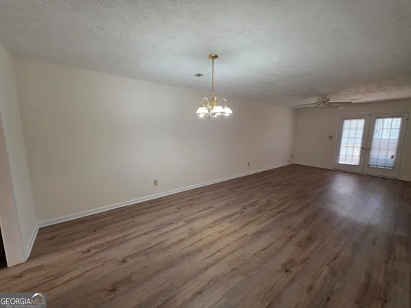 a view of a room with wooden floor and chandelier