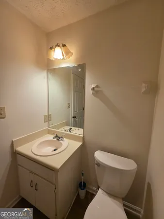 a bathroom with a toilet sink and mirror