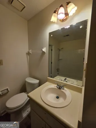 a bathroom with a sink a toilet and a mirror
