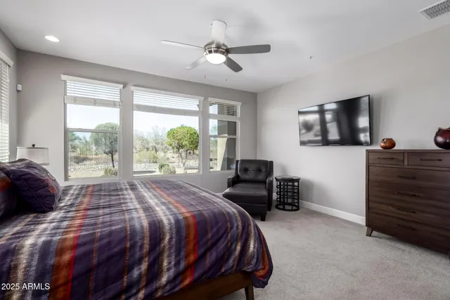 a bedroom with a bed a couch and a flat screen tv