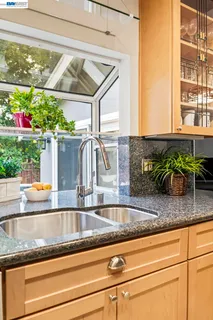 a kitchen sink with granite countertop a window and a sink