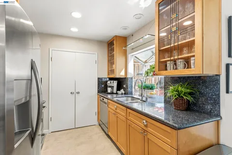a kitchen with stainless steel appliances granite countertop a refrigerator and a sink
