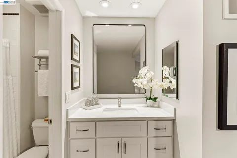 a bathroom with a granite countertop sink and a mirror