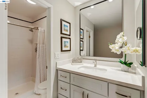 a bathroom with a granite countertop sink a toilet and shower