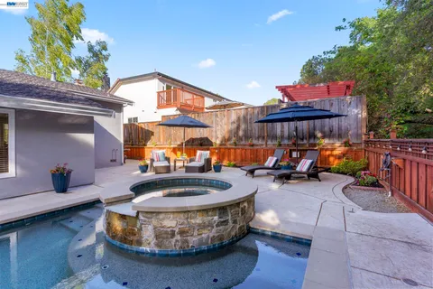 a view of a patio with table and chairs potted plants and a large tree