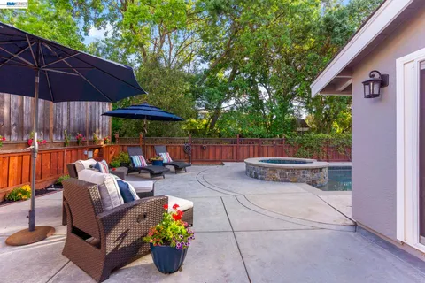 an outdoor sitting area with furniture and umbrella