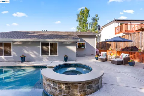 a view of a house with backyard sitting area and swimming pool