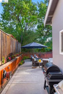 a backyard of a house with barbeque oven table and chairs