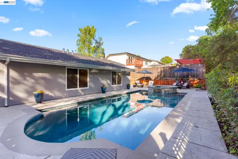 a view of a house with backyard and sitting area