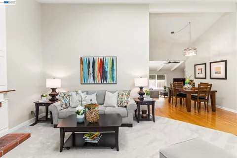 a living room with furniture and a dining table with kitchen view
