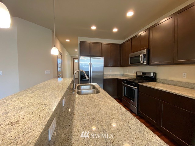 419 203rd Place Southeast Bothell, WA 98012 - Photo 22 of 30 a large kitchen with kitchen island a large counter top space appliances and cabinets