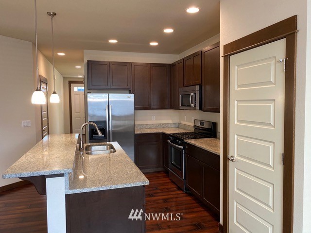419 203rd Place Southeast Bothell, WA 98012 - Photo 24 of 30 a kitchen with stainless steel appliances granite countertop a sink a stove and a refrigerator