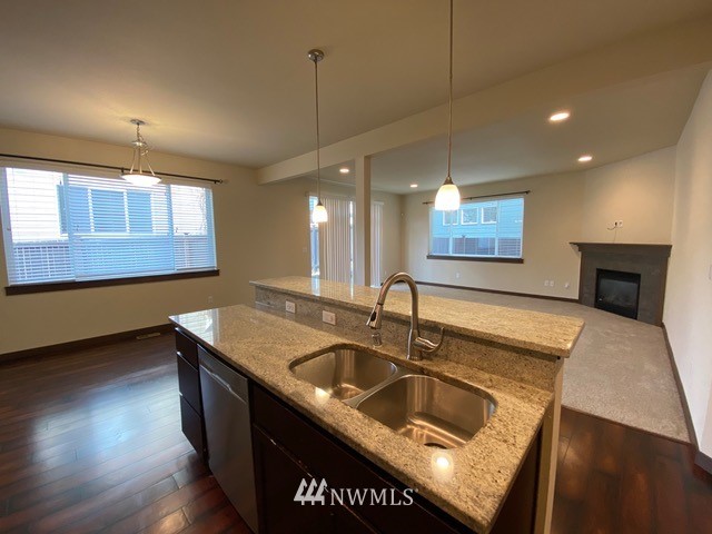 419 203rd Place Southeast Bothell, WA 98012 - Photo 27 of 30 a kitchen with stainless steel appliances granite countertop a sink a stove and a wooden floor
