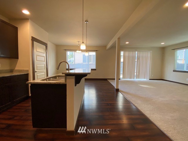 419 203rd Place Southeast Bothell, WA 98012 - Photo 5 of 30 a kitchen with stainless steel appliances granite countertop a refrigerator a sink dishwasher a stove and a dining table with wooden floor