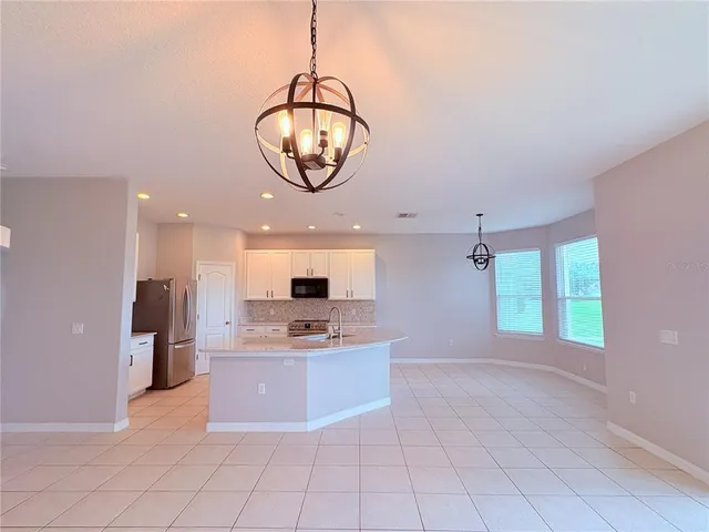 a large kitchen with stainless steel appliances cabinets a sink and a counter top space