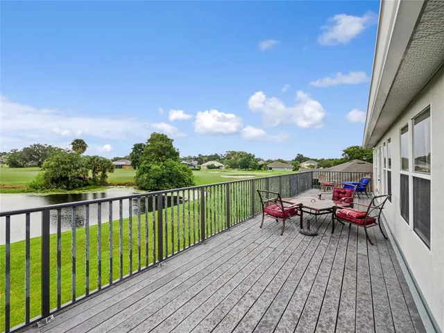 a view of a balcony with wooden floor and outdoor seating