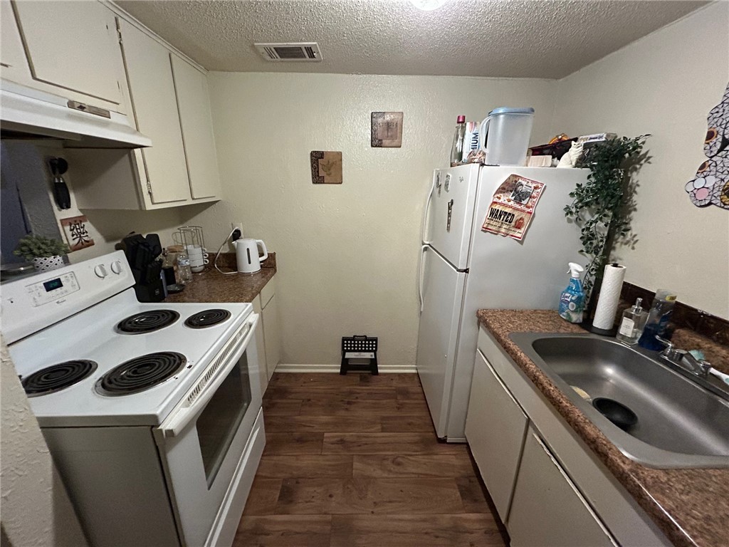 4405 Carter Creek Parkway, Unit 9 Bryan, TX 77802 - Photo 5 of 11 a kitchen that has a sink and a stove in it