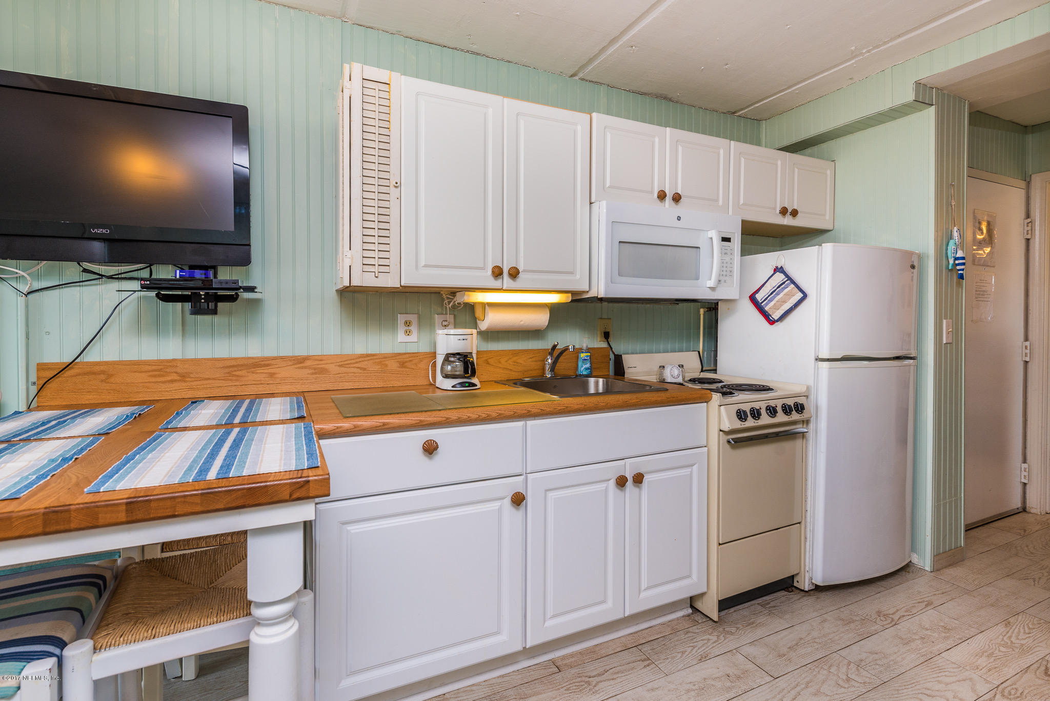 6970 A1A South, Unit 133 St. Augustine, FL 32080 - Photo 7 of 26 a kitchen with white cabinets and refrigerator