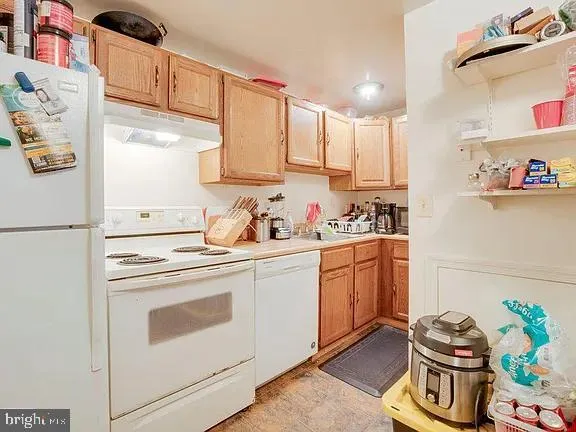 a kitchen with stainless steel appliances granite countertop a sink and a refrigerator
