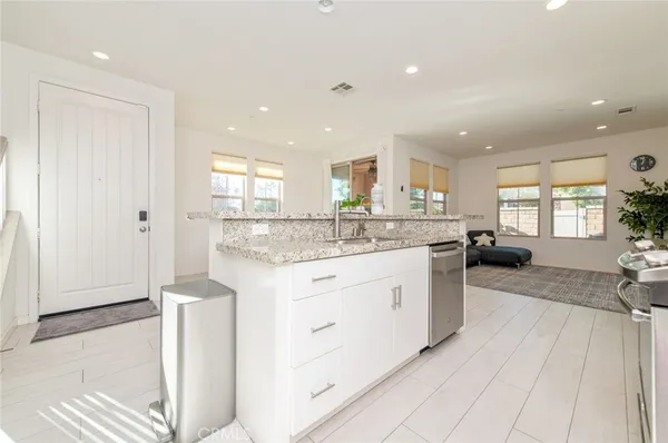 a kitchen with stainless steel appliances granite countertop a sink a stove and a refrigerator