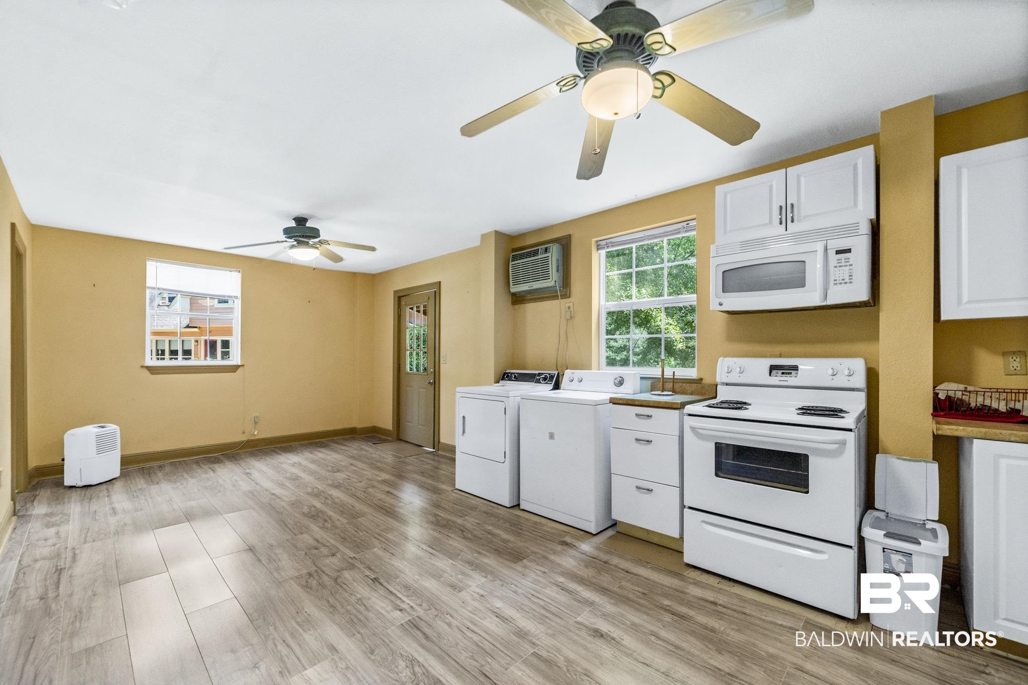 8321 Dixon Road Bay Minette, AL 36507 - Photo 61 of 79 Kitchen featuring white appliances, light wood-type flooring, white cabinetry, ceiling fan, and washing machine and dryer