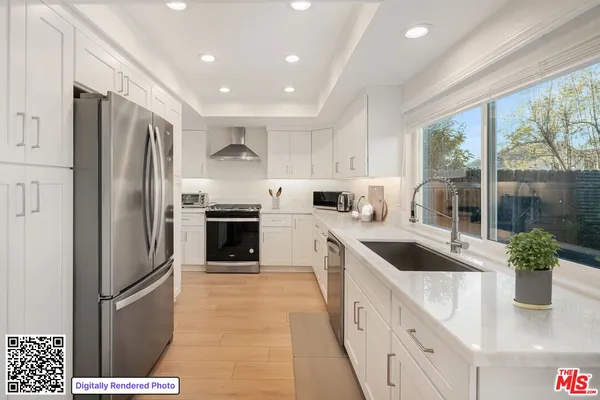 a kitchen with granite countertop a refrigerator and a sink