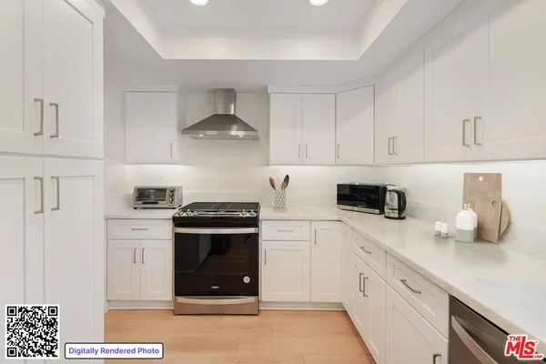 a kitchen with stainless steel appliances a stove a sink and white cabinets