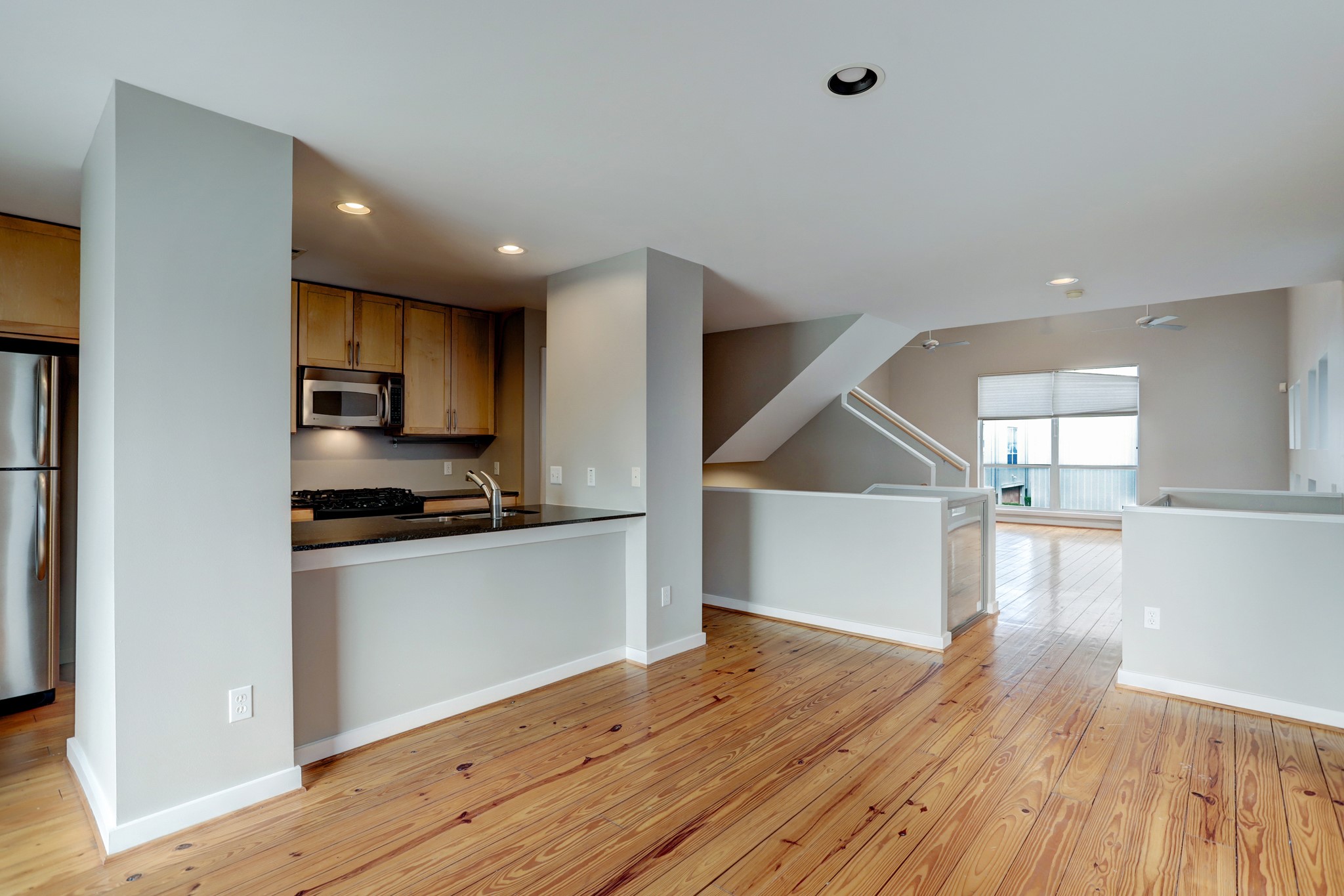 835 Saulnier Street Houston, TX 77019 - Photo 3 of 10 a kitchen with stainless steel appliances granite countertop a refrigerator a sink dishwasher a stove and white countertops with wooden floor