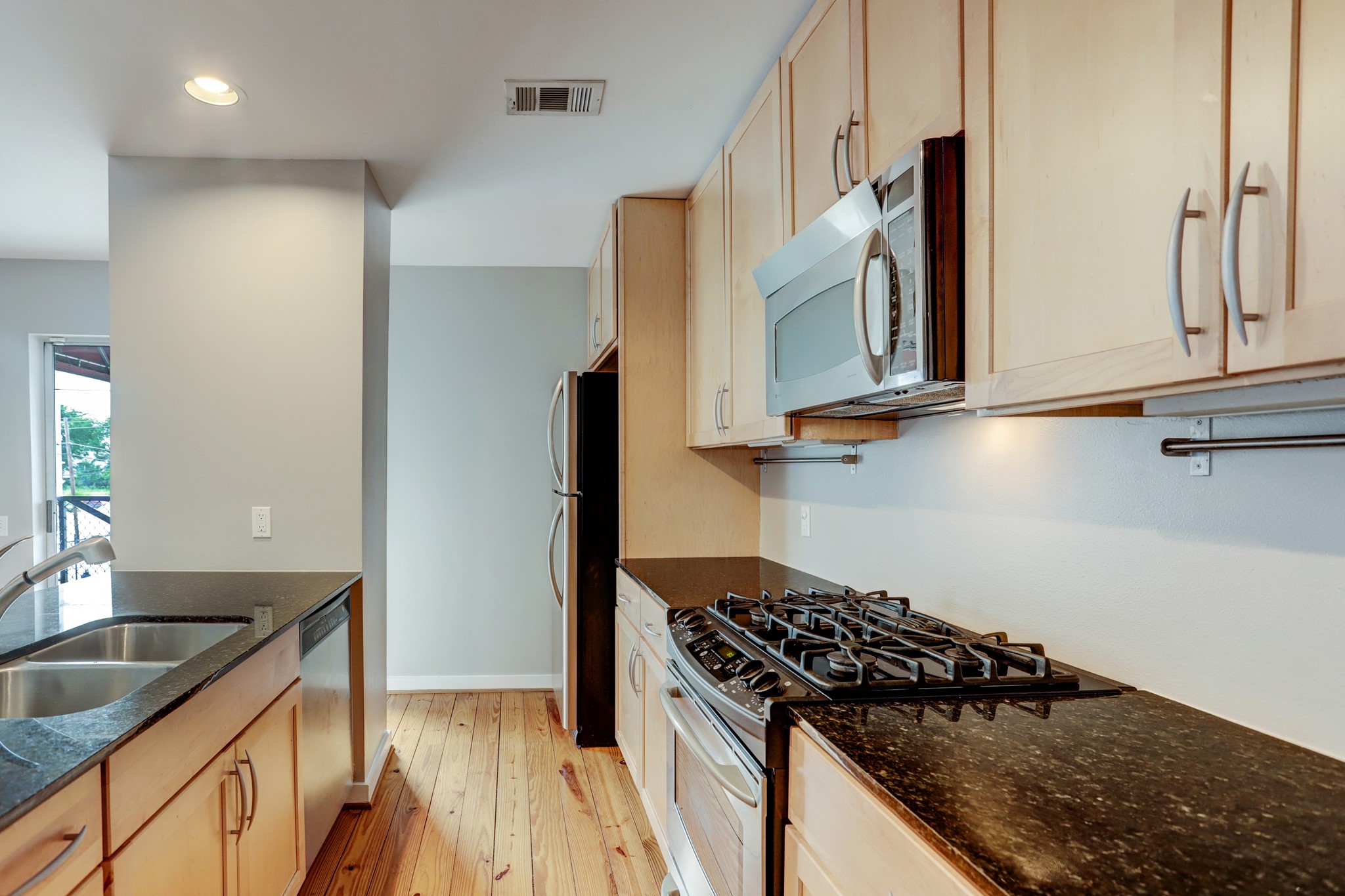 835 Saulnier Street Houston, TX 77019 - Photo 4 of 10 a kitchen with granite countertop a sink stove and refrigerator
