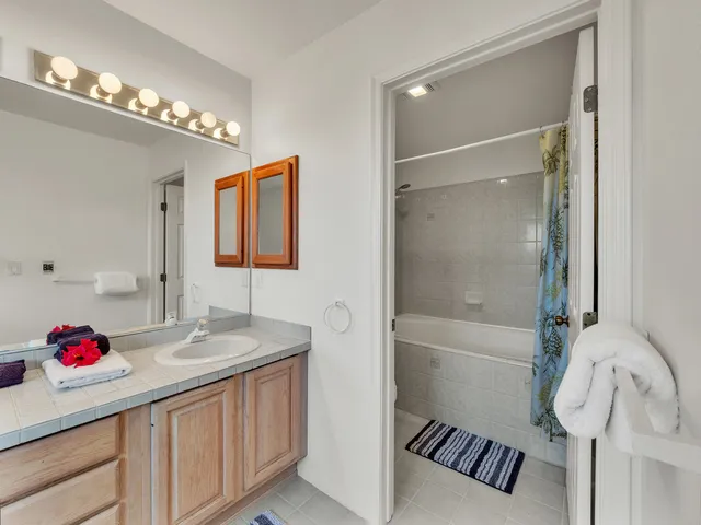 a bathroom with a sink vanity tub and shower