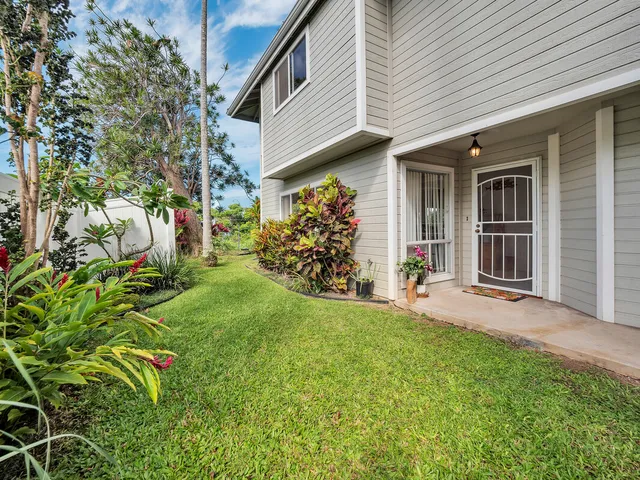 a view of a porch with potted plants and floor to ceiling window