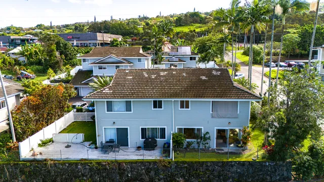 a view of a house with a yard and potted plants