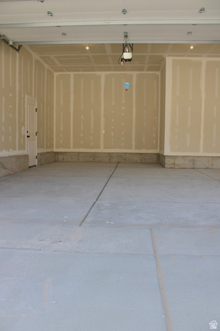 2613 Scarlet Road, Unit 258 Eagle Mountain, UT 84005 - Photo 31 of 32 Spacious garage featuring a concrete floor, unpainted drywall, and an overhead garage door opener