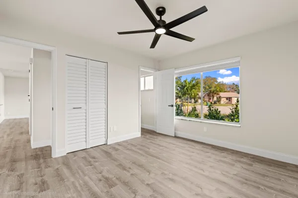 an empty room with wooden floor and windows