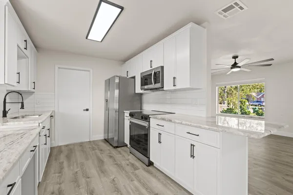 a kitchen with stainless steel appliances granite countertop a stove a sink and a refrigerator