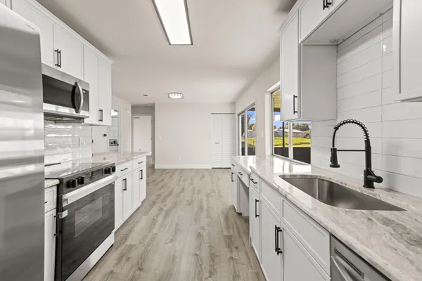 a kitchen with stainless steel appliances granite countertop a sink and stove