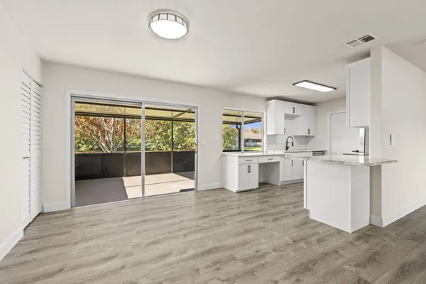 a view of a kitchen with wooden floor and a window