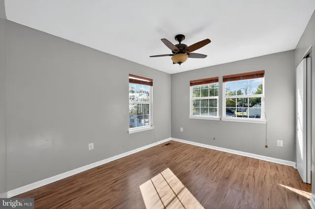 a view of an empty room and window and wooden floor