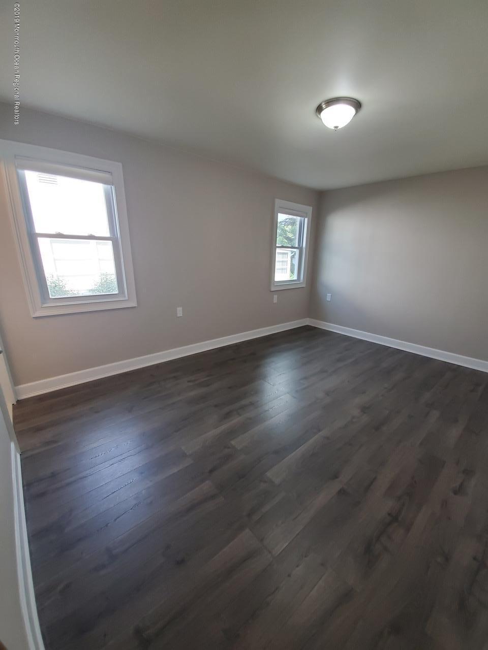 7 Patmore Road Brick, NJ 08724 - Photo 5 of 10 an empty room with wooden floor and windows