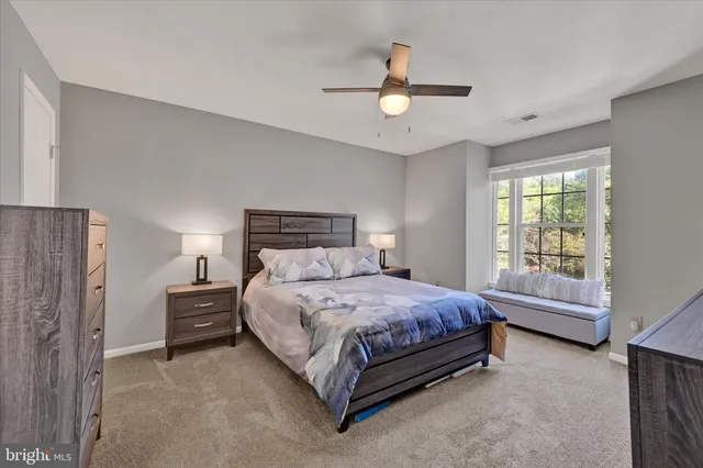 a bedroom with a bed a chandelier and a dresser