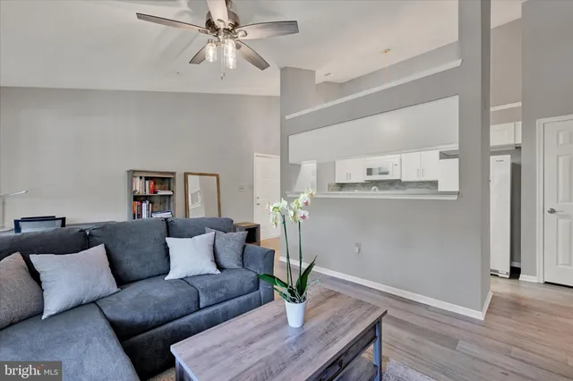 a living room with stainless steel appliances furniture and wooden floor