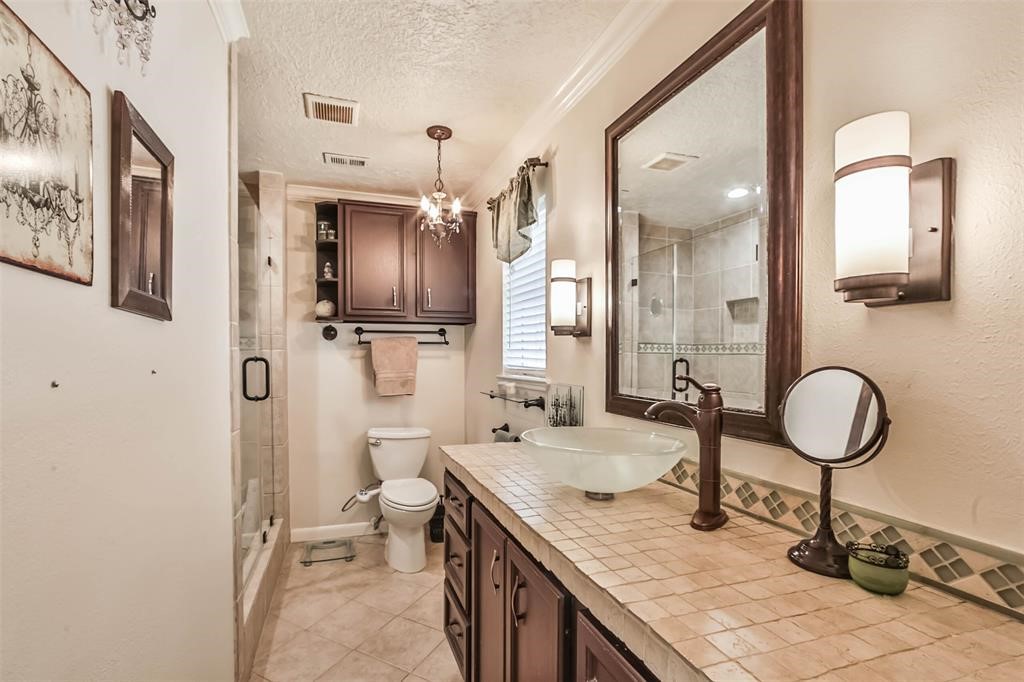 6911 Sprigg Street Fulshear, TX 77441 - Photo 22 of 48 a bathroom with a granite countertop sink a toilet and a mirror