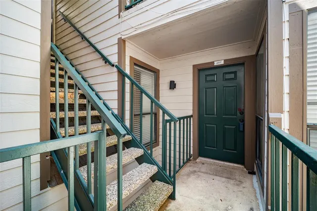 a view of staircase with railing and white walls