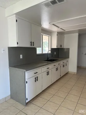 a kitchen with granite countertop a sink and a stove top oven