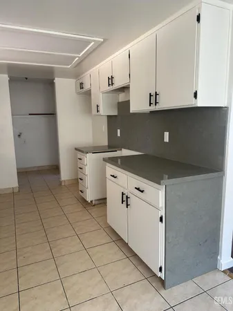 a kitchen with white cabinets and white appliances