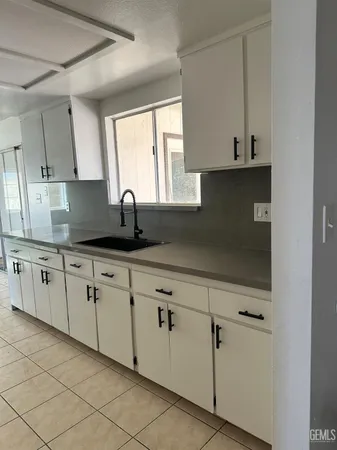 a kitchen with granite countertop white cabinets and sink