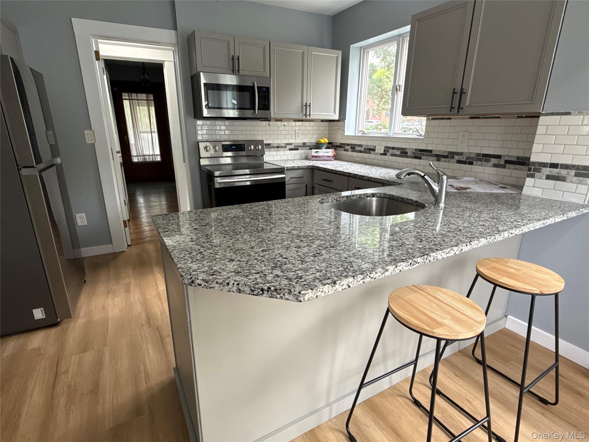 110 Innis Avenue Poughkeepsie, NY 12601 - Photo 5 of 22 a kitchen with stainless steel appliances granite countertop a sink refrigerator and stove