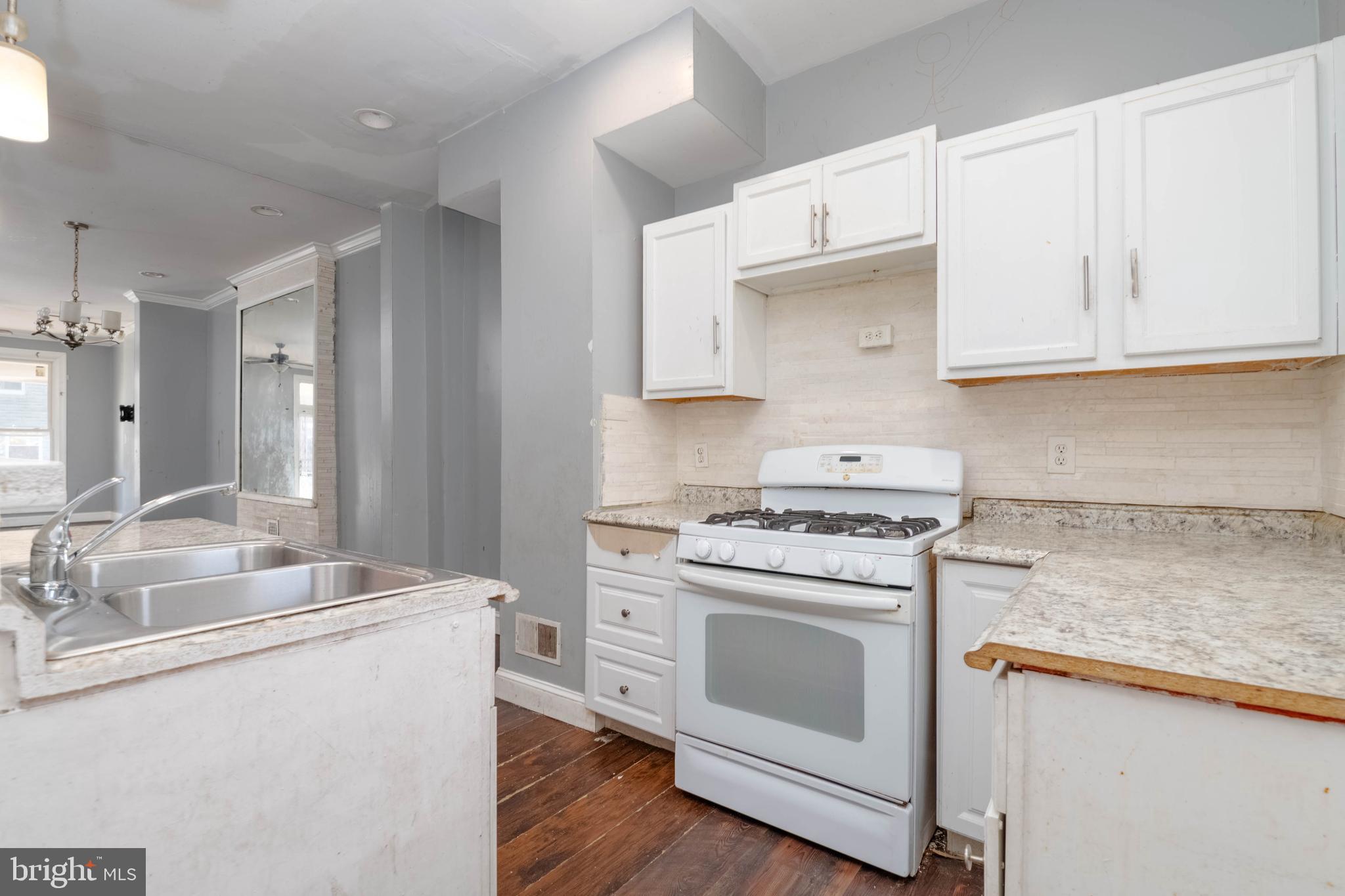 2216 West Fayette Street Baltimore, MD 21223 - Photo 11 of 36 a kitchen with granite countertop white cabinets and white appliances