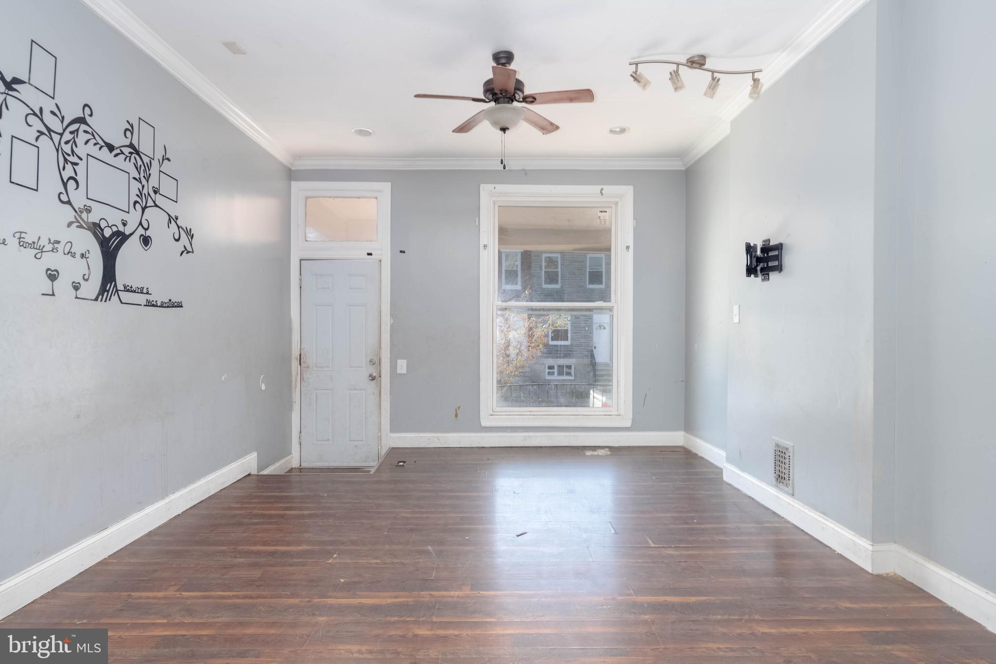 2216 West Fayette Street Baltimore, MD 21223 - Photo 4 of 36 a view of an empty room with wooden floor and a window