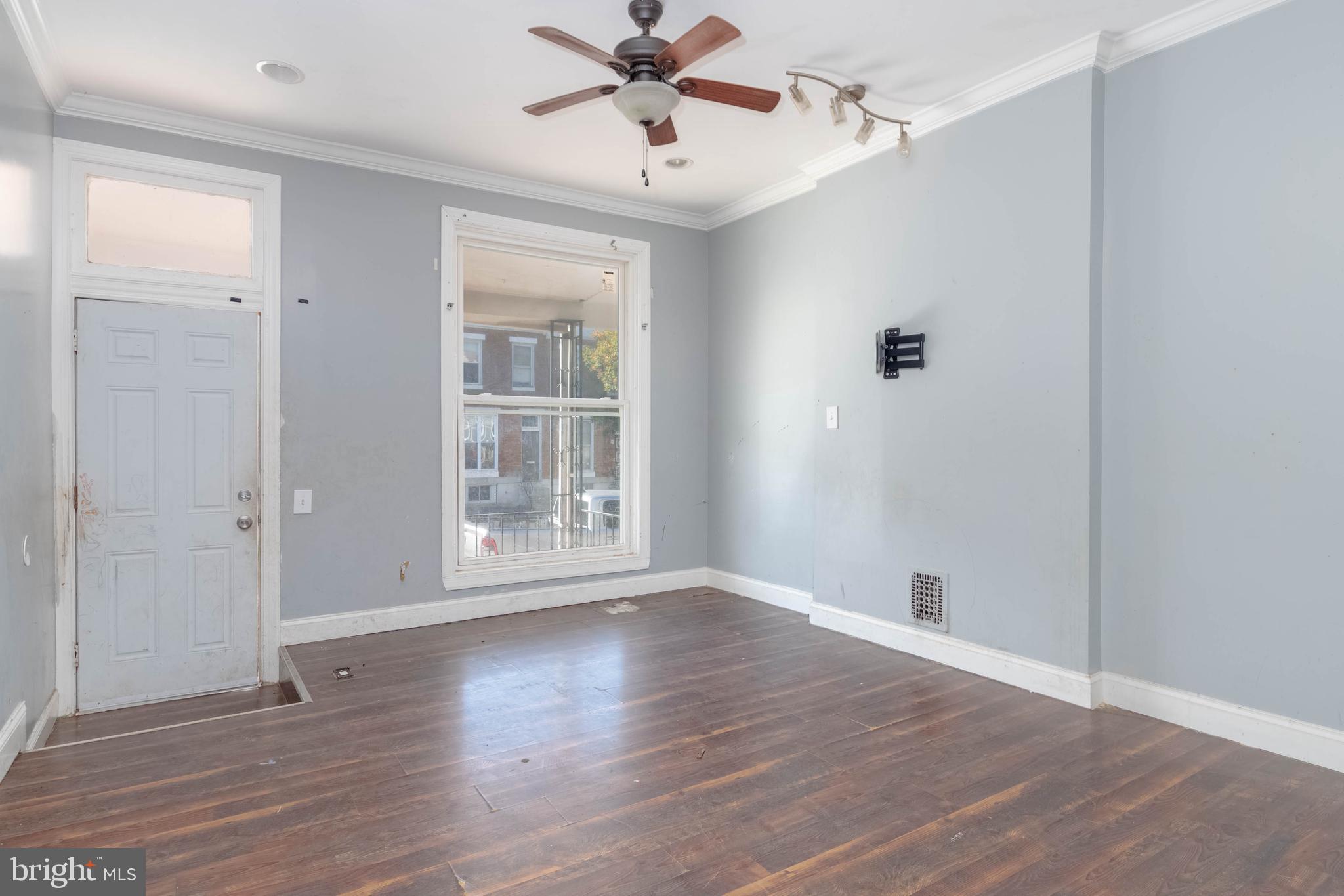 2216 West Fayette Street Baltimore, MD 21223 - Photo 5 of 36 a view of an empty room with wooden floor and a window